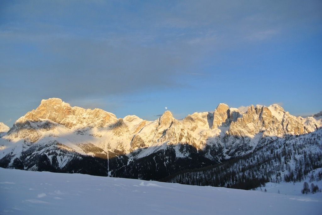Eine Berglandschaft mit schneebedeckten Gipfeln und blauem Himmel.