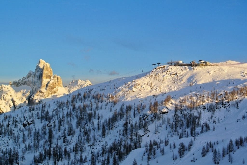 A snow-covered mountain with a ski lift and a prominent peak.