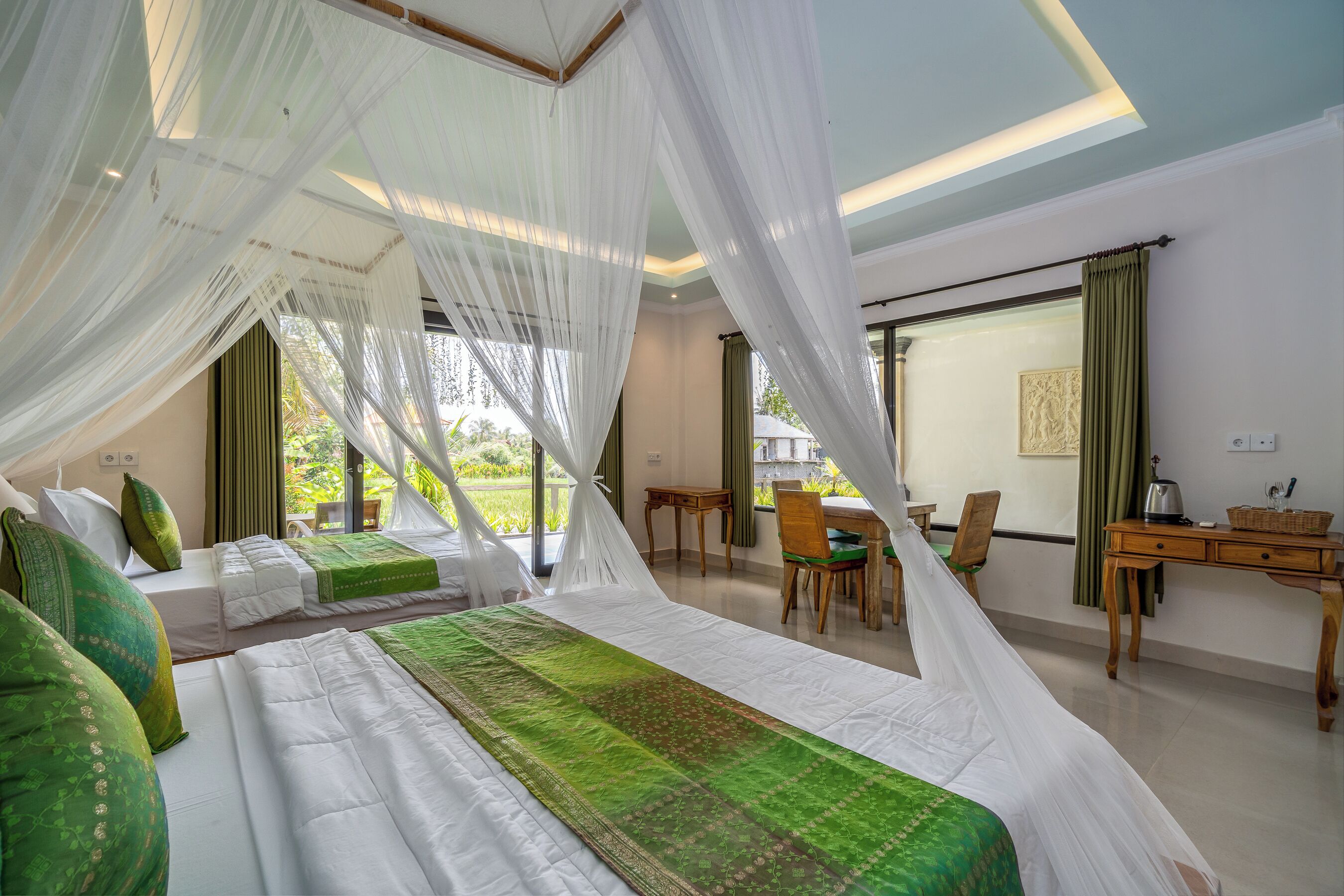 A bedroom with two beds, a desk, and a chair.