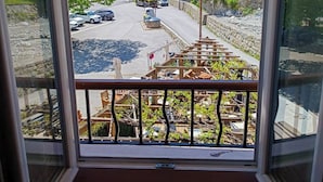 A balcony with a view of a town, a bridge, and a truck on the road.