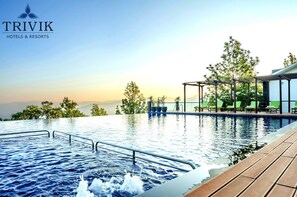 A pool area with a view of mountains, a covered seating area, and a wooden deck. - Trivik Hotels & Resorts, Chikmagalur (Chikkamagaluru)