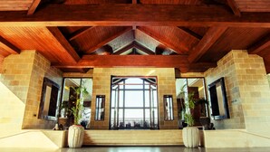 A spacious lobby with a high wooden ceiling, large windows, and potted plants. - Trivik Hotels & Resorts, Chikmagalur (Chikkamagaluru)