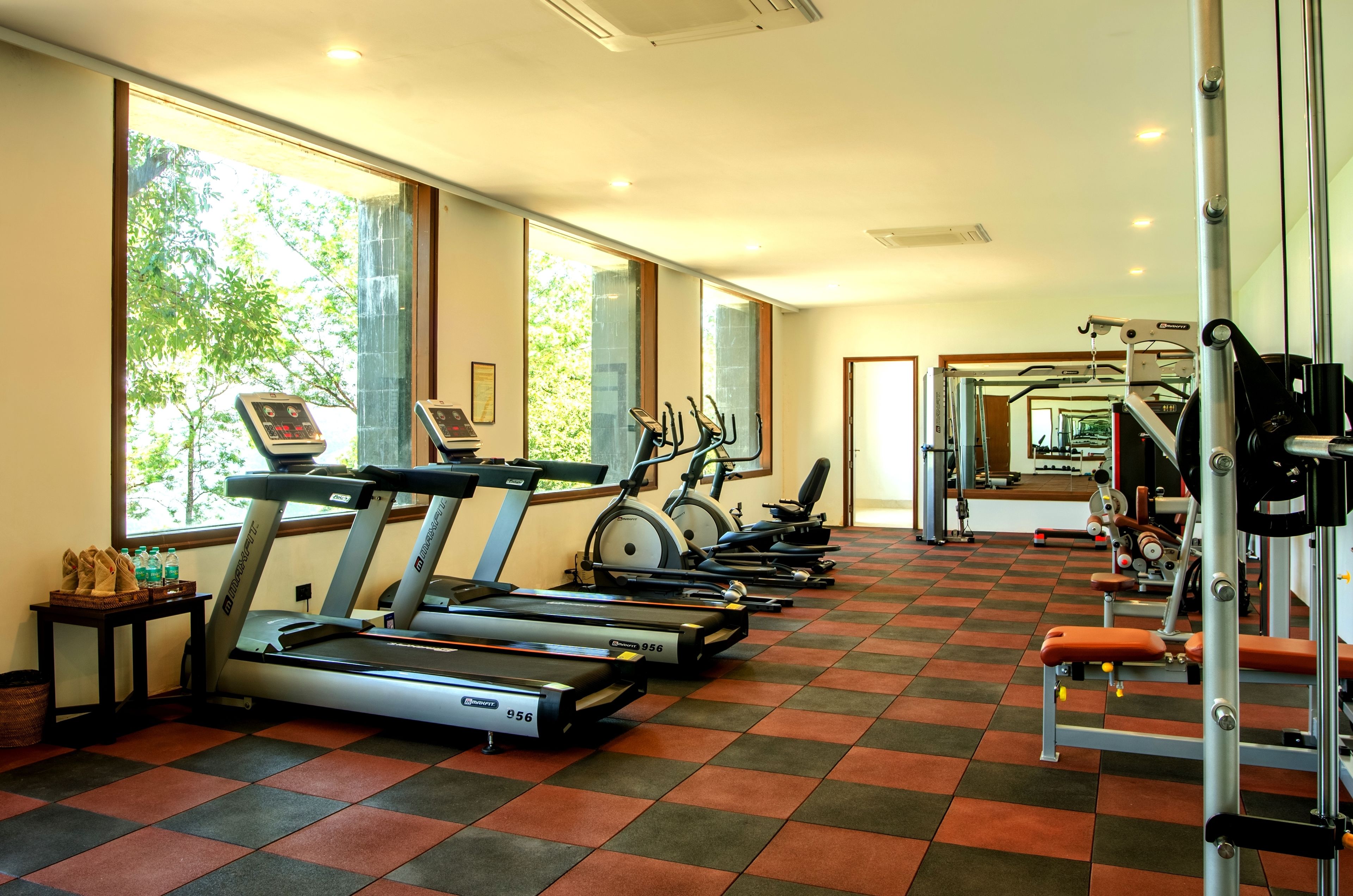 Un gimnasio con cintas de correr, bicicletas estáticas y máquinas de pesas.