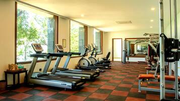 Un gimnasio con cintas de correr, bicicletas estáticas y máquinas de pesas.