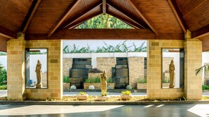 A covered outdoor area with stone statues and planters. - Trivik Hotels & Resorts, Chikmagalur (Chikkamagaluru)