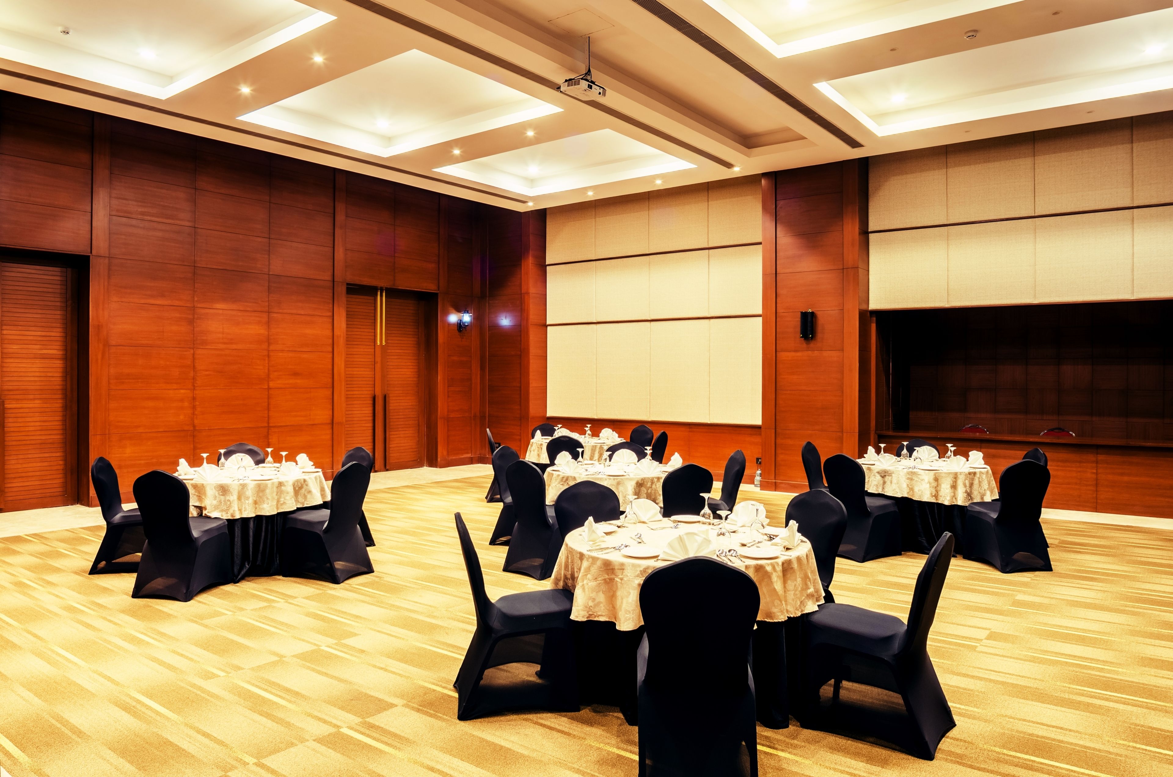 A conference room with multiple tables set for dining, equipped with chairs and table settings.