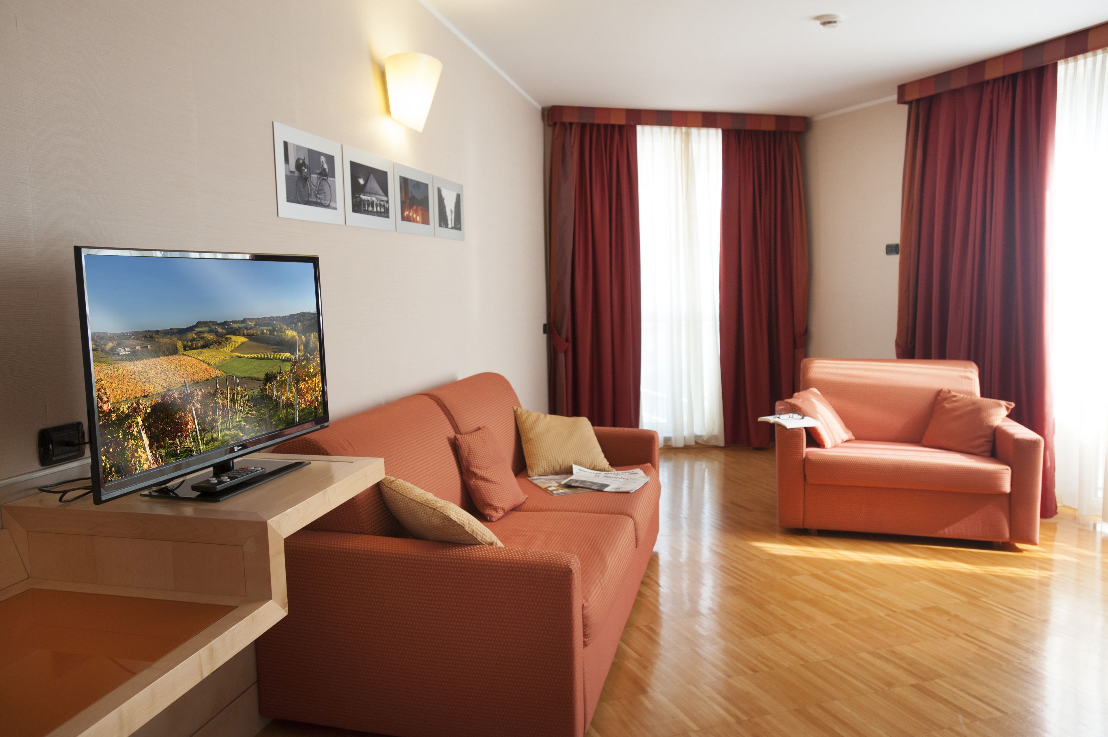 A modern living room with a flat-screen TV, two sofas, and a wooden coffee table.