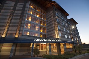 A multi-story hotel with a prominent entrance and illuminated windows.