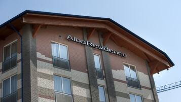 A multi-story building with the sign "AlbaResidence" on the facade.
