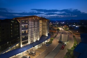 A modern hotel with a glass facade, a covered entrance, and a parking area. - AlbaResidence masera26 (Alba)