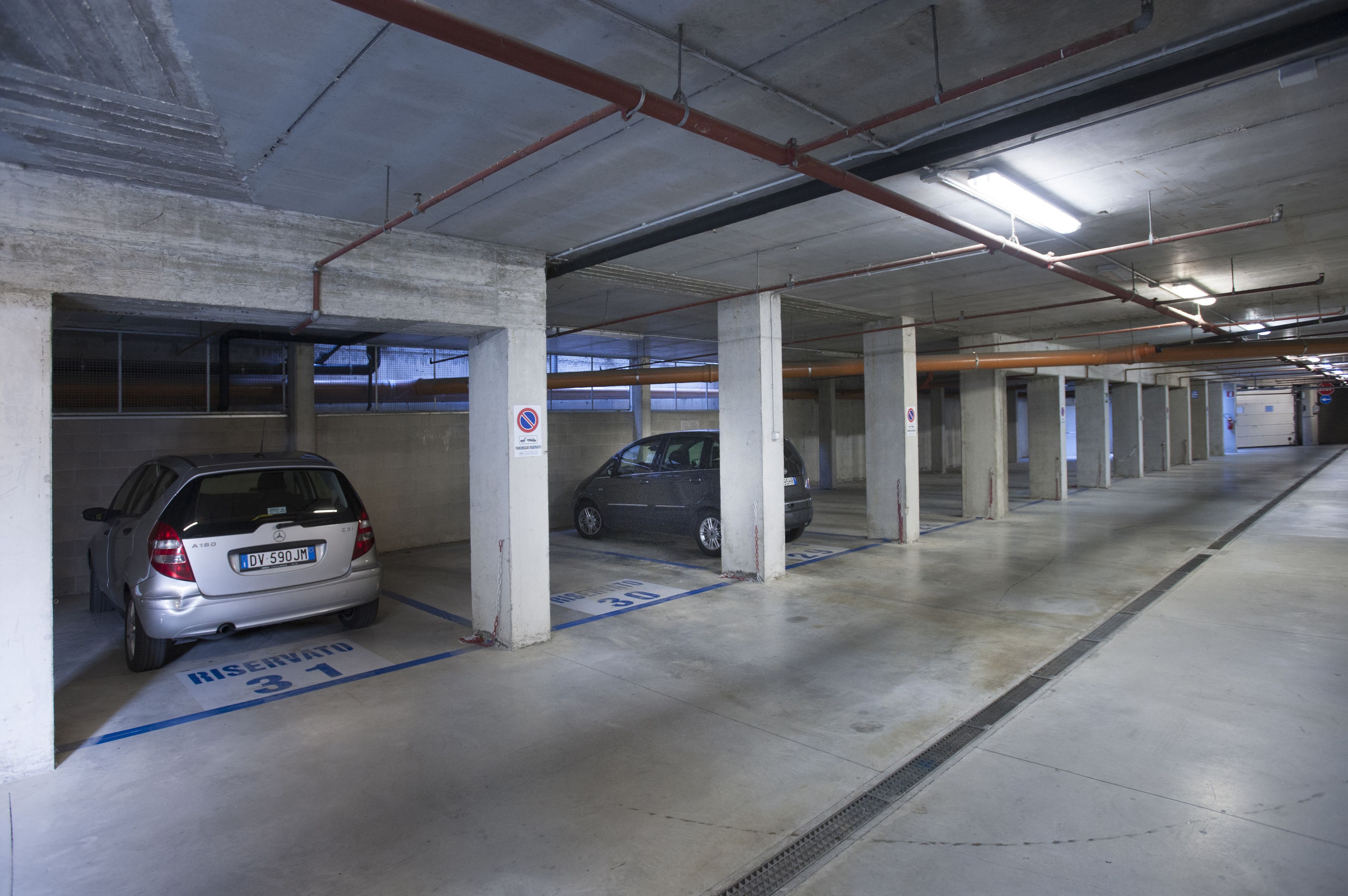 A multi-level parking garage with concrete pillars and marked parking spaces.