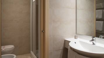 Un bagno moderno con doccia, servizi igienici e lavandino.