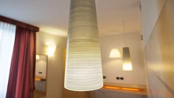 Un luminaire suspendu moderne, de forme cylindrique, installé dans le couloir d’un hôtel.