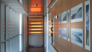 A hallway with a wooden wall displaying framed photographs. - AlbaResidence masera26 (Alba)