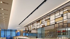 Un interior moderno con una isla central, ventanas amplias y un techo alto.
