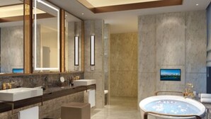 Un baño moderno con dos lavamanos, una bañera y un espejo grande.