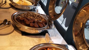 A buffet with various food items including hot dogs, peanuts, and other snacks.