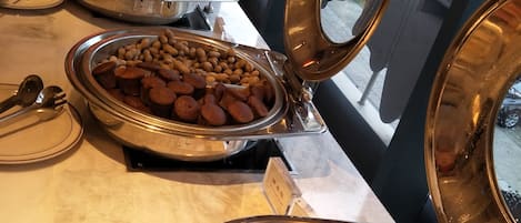 A buffet with various food items including hot dogs, peanuts, and other snacks.