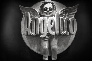 A sculpture with the word "Angel" and wings, set against a circular backdrop. - Saint Gabriel Hotel (Bethlehem)