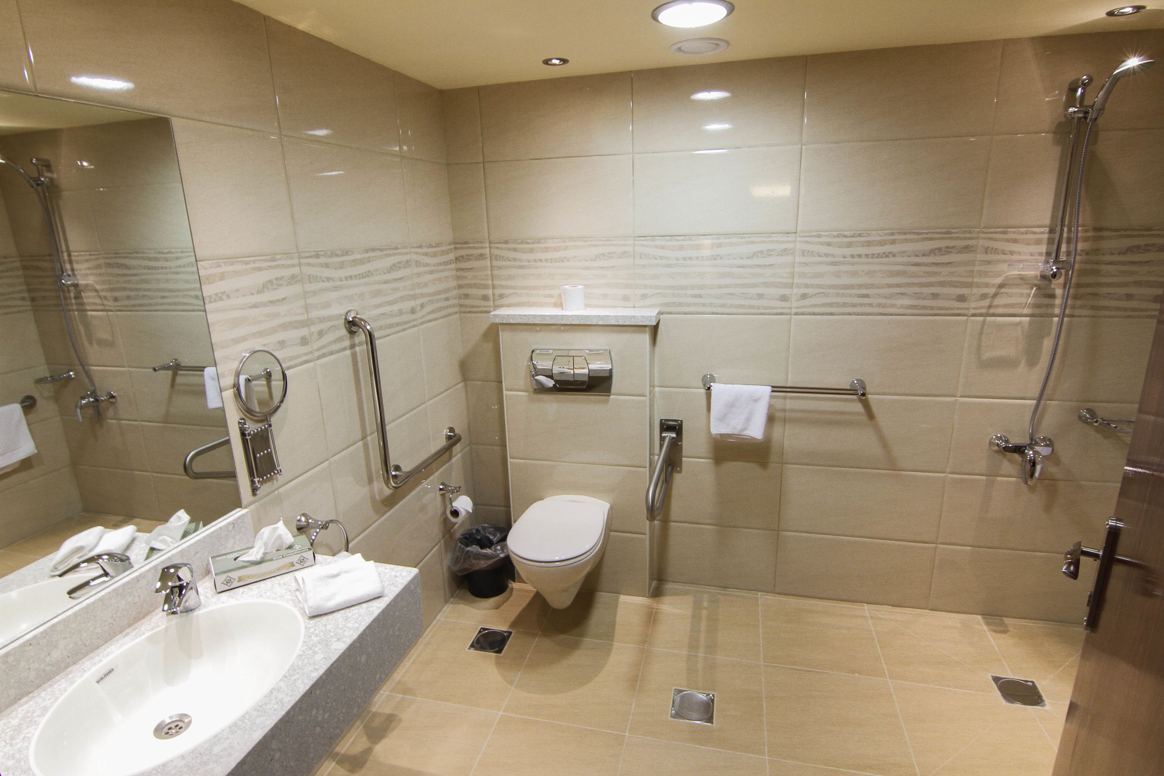 A modern bathroom with a sink, toilet, and shower.