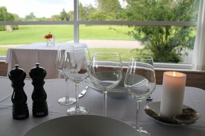 A table set for dining with salt and pepper shakers, wine glasses, and a candle. - Blokhus Golfcenter (Pandrup)