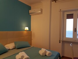 Quarto com cama, janela com vista, ar condicionado e abajur.