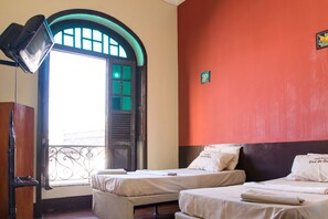 A hotel room with two beds, a window with a view, a decorative mirror, and a wall-mounted sign. - Hotel Cruz de Ouro (Rio de Janeiro)