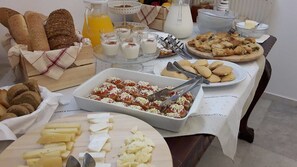 Un bufé de desayuno con panes, bollería y queso variado.