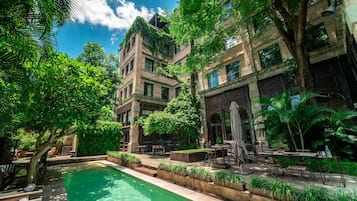 Una piscina al aire libre, sillones reclinables de piscina