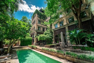 Una piscina al aire libre, sillones reclinables de piscina