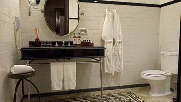 A bathroom with a black countertop sink, a mirror, a toilet, and a patterned floor.