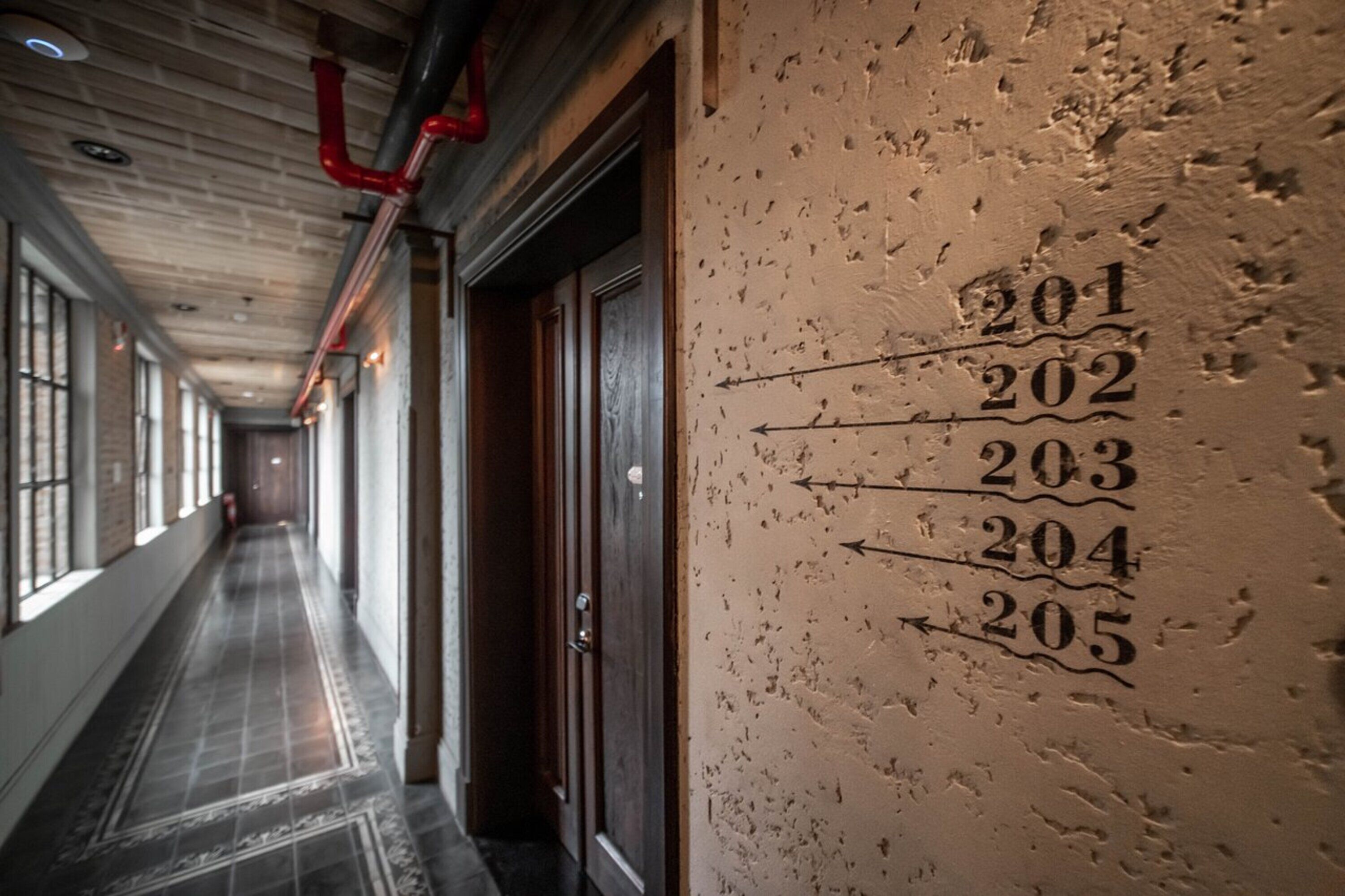 A hallway with numbered doors from 201 to 205, indicating room numbers.