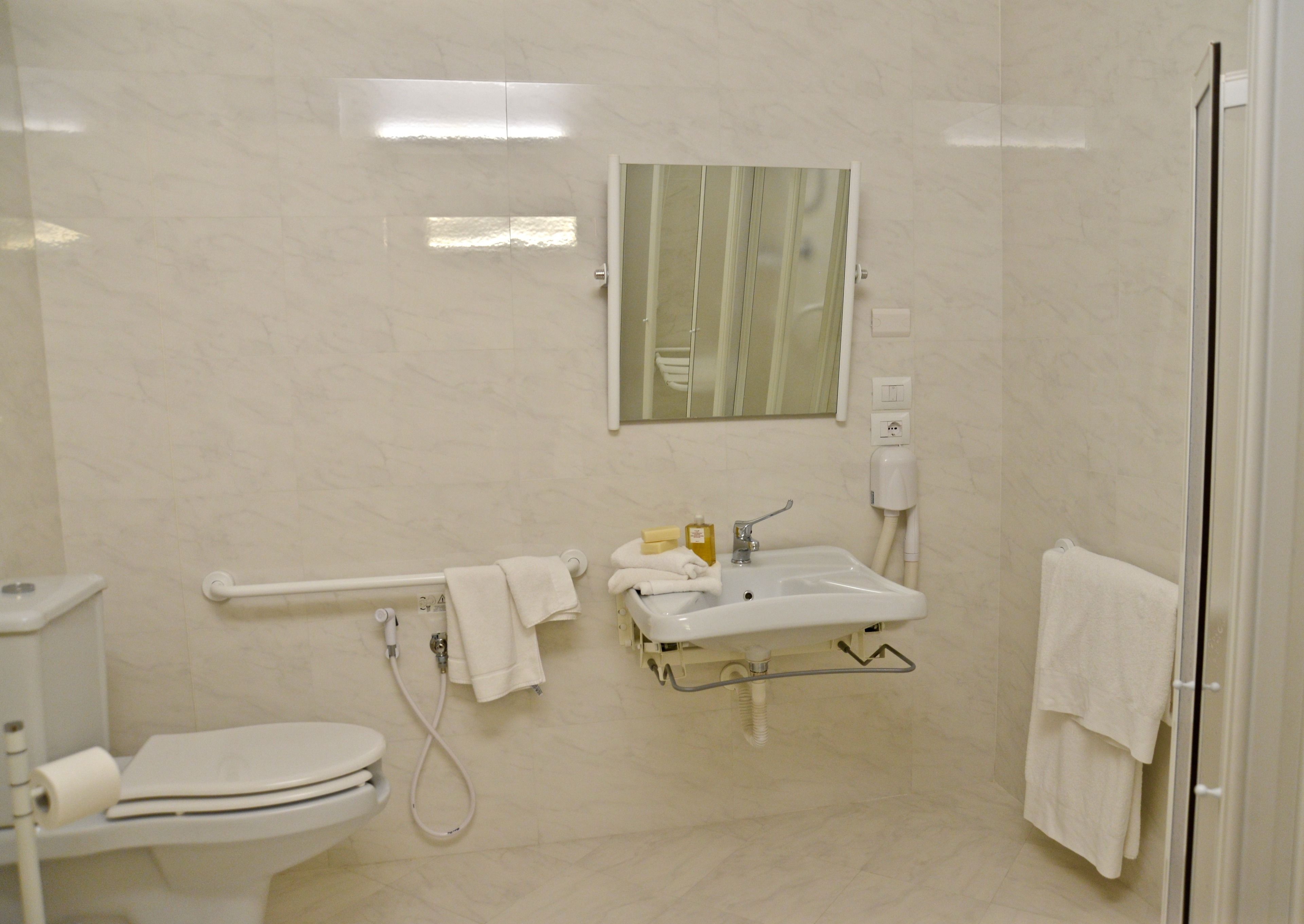 A modern bathroom with a toilet, sink, and glass shower enclosure.