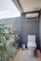 Un baño moderno con inodoro, toallero y cubo de basura.