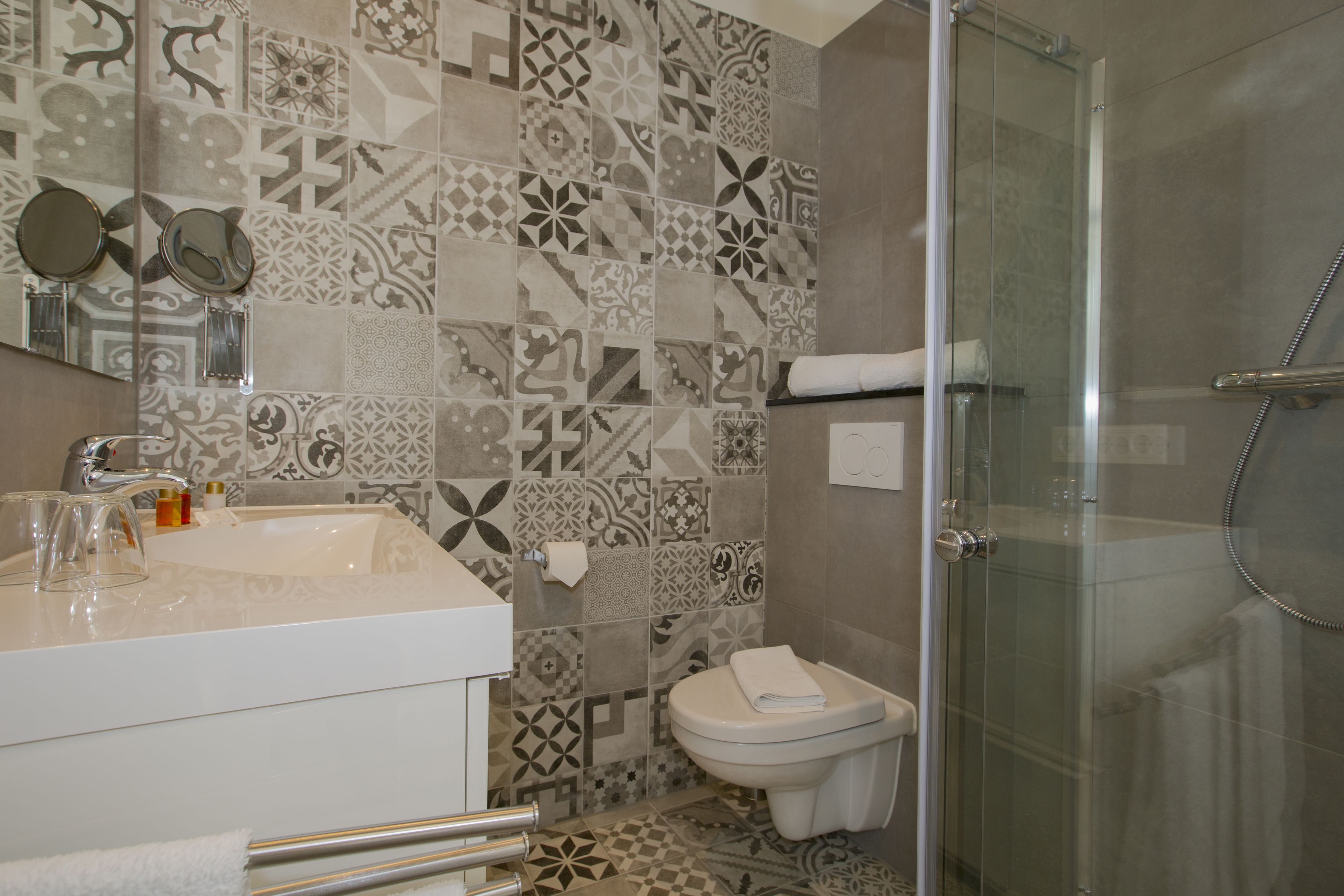 A bathroom with a white sink, a toilet, and a glass-enclosed shower.