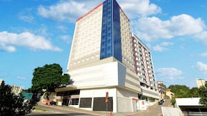 Un hotel moderno con una fachada de vidrio destacada, varios pisos y techo plano.