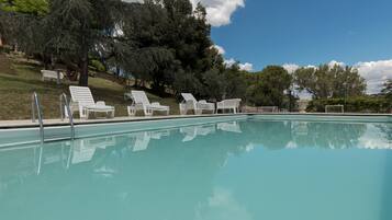 Kolam renang outdoor musiman, dengan kursi berjemur