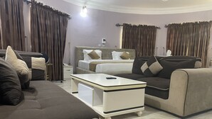 Una habitación de hotel moderna con una cama, un sofá y una pequeña mesa blanca.