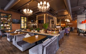 A modern bar area with seating, a bar counter, and a television screen. - Park Inn by Radisson Residence Riga Barona (Riga)