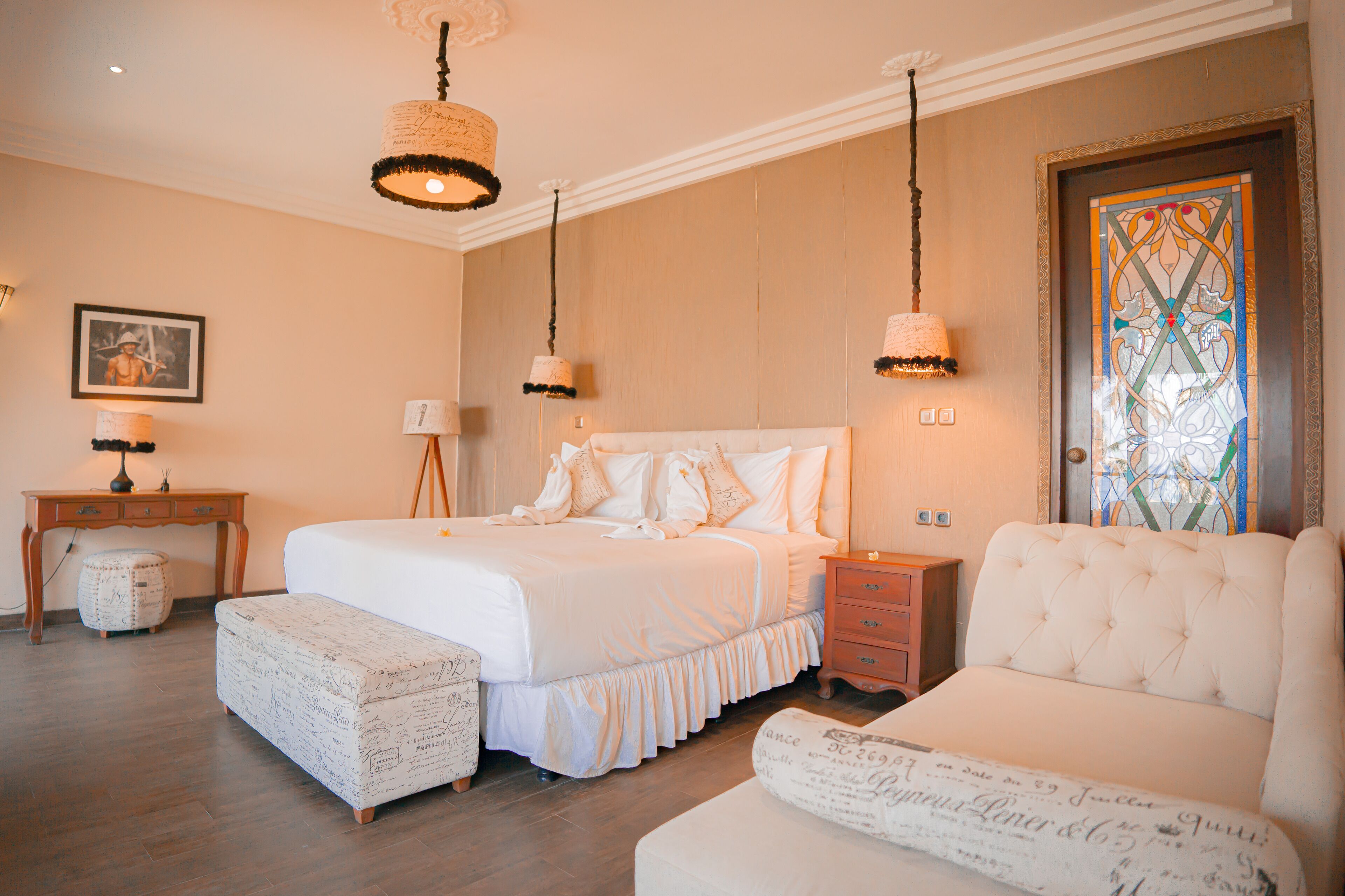 A bedroom with a large bed, a sofa, a desk, and a chair.