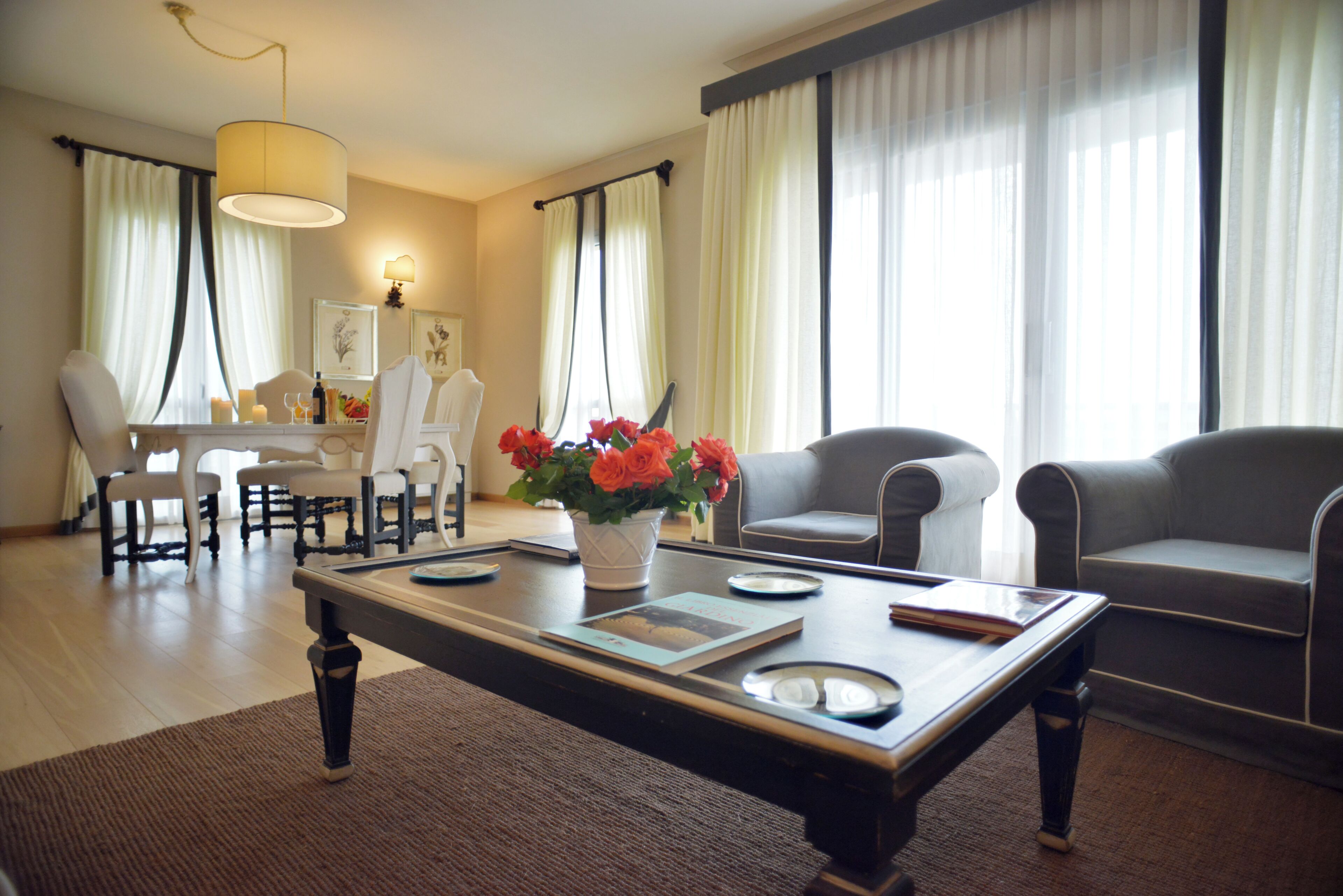 A modern living room with a dining area, featuring a coffee table, sofas, and a dining table with chairs.
