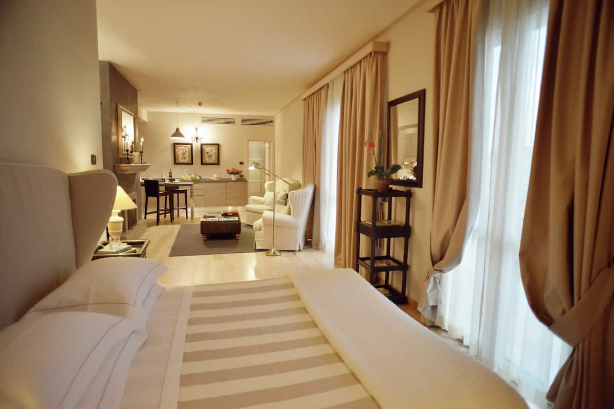Ein Hotelzimmer mit einem großen Bett, einem Schreibtisch, einem Sessel, einer Couch und einem kleinen Tisch.