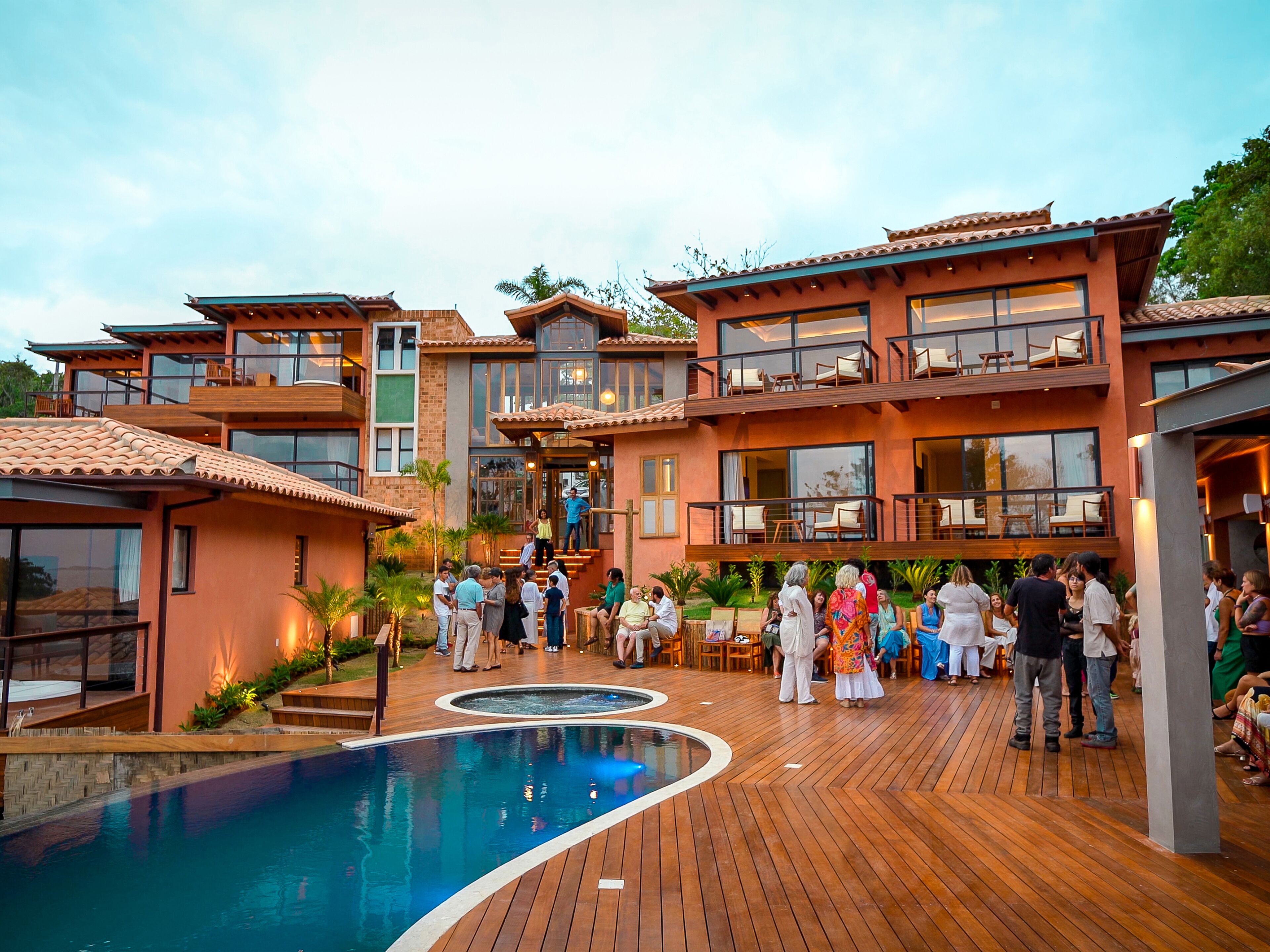 Un resort con varias construcciones, un área de piscina central y asientos al aire libre.
