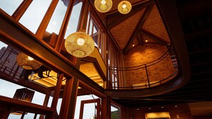 A spacious interior with high ceilings, large windows, and hanging spherical light fixtures. - Búzios Espiritualidade Hotel (Búzios)
