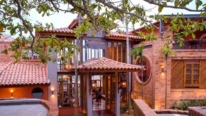 A traditional building with a tiled roof, a covered entrance, and a brick exterior. - Búzios Espiritualidade Hotel (Búzios)