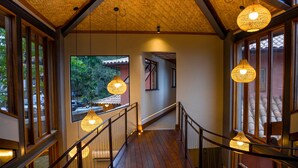 A wooden staircase with glass railings and hanging wicker lamps. - Búzios Espiritualidade Hotel (Búzios)