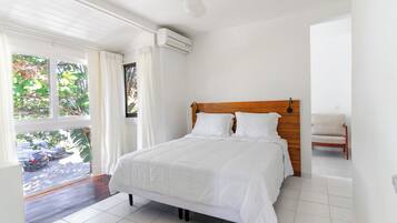 A bedroom with a bed, a ceiling fan, and a window with curtains.