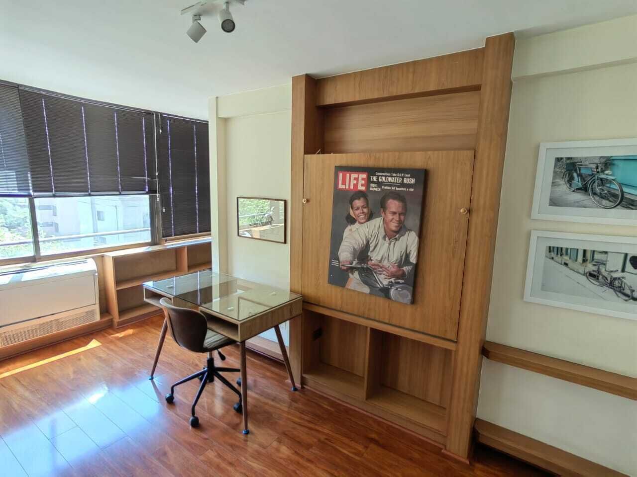 Een moderne kantoorruimte met een glazen bureau, een tijdschrift in een lijst aan de muur, en een foto van een fiets.