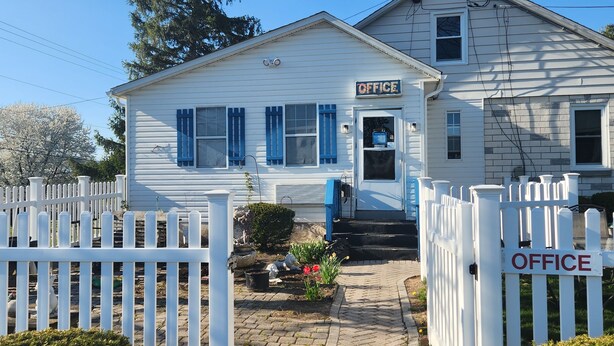 A two-story white building with a sign reading "OFFICE" on the front. - Blue Sky Motel (Gettysburg)
