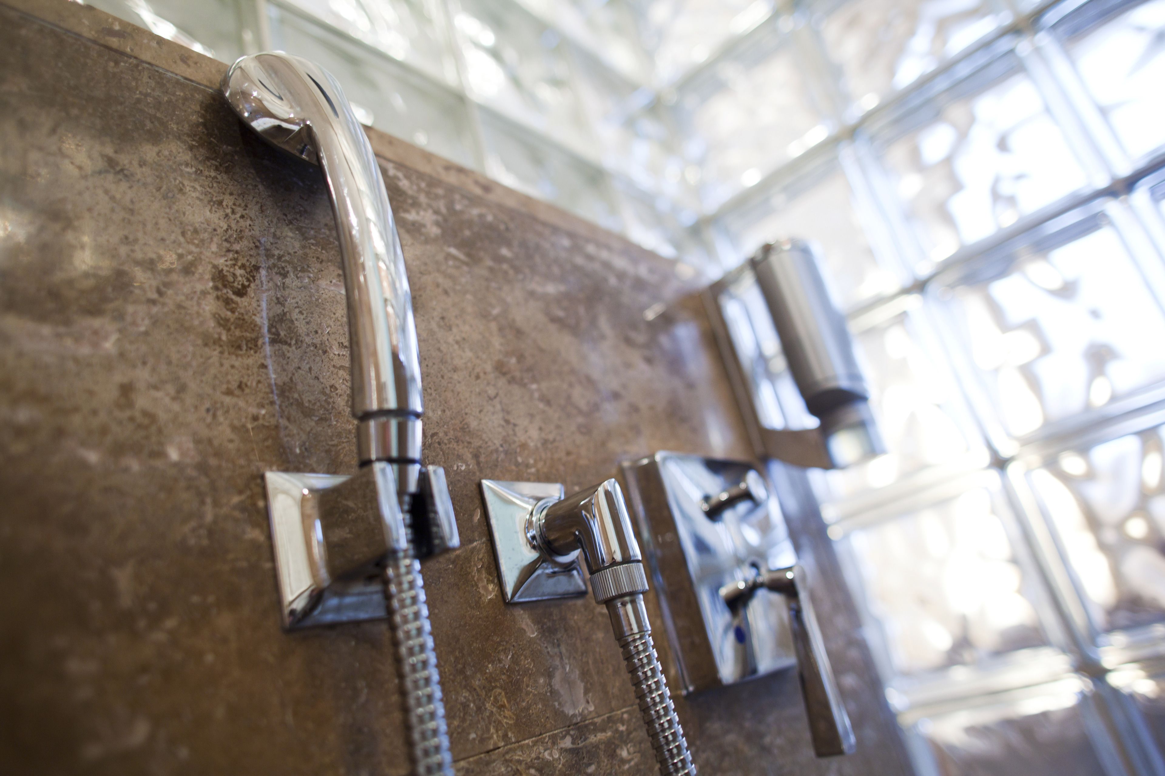 A bathroom with a shower area featuring chrome fixtures and a glass enclosure.